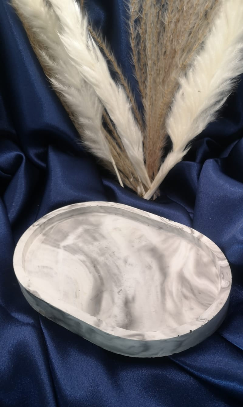 Marble-patterned stone on a blue fabric background with feathers